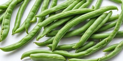 The primary subject of the image is a close-up of green beans, which are the main objects in the scene. The beans are displayed on a white surface, which serves as the background. The visual style of the image is a photo, capturing the details and colors of the green beans. The dominant colors in the image are green, which is the color of the beans, and white, which is the color of the surface they are placed on. The overall atmosphere of the image is fresh and natural, as it show