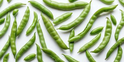 The primary subject of the image is a large number of green beans, which are arranged in a pattern on a white surface. The beans are displayed in various orientations, creating a visually appealing and colorful scene. The setting appears to be a white background, which allows the green beans to stand out as the main focus of the image. The visual style of the image is a close-up of the beans, showcasing their details and textures. The colors and mood of the image are predominantly
