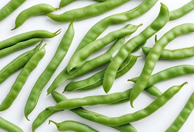 The primary subject of the image is a large group of green beans, which are the main objects in the scene. The beans are arranged on a white surface, which serves as the background. The visual style of the image is a close-up of the green beans, showcasing their texture and details. The colors in the image are predominantly green, which gives the scene a fresh and vibrant atmosphere.