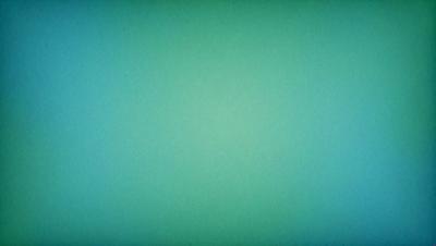 The primary subject of the image is a large, empty, and bright green wall. The setting is a room with a blue background, which creates a contrasting and vibrant atmosphere. The visual style is a close-up of the green wall, showcasing its color and texture. The colors and mood of the image are predominantly green and bright, giving the impression of a fresh and lively space.