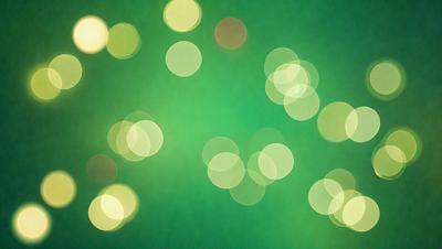 The primary subject of the image is a green background with a pattern of bright, glowing lights. The setting appears to be a dark room, and the visual style is a combination of a photo and digital art. The colors and mood of the image are predominantly green, with the glowing lights adding a sense of warmth and energy to the scene.