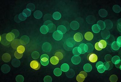 The primary subject of the image is a brightly lit green light, which appears to be a neon light or a light source with a green hue. The setting is a dark background, which contrasts with the bright green light. The visual style of the image is a close-up of the green light, emphasizing its vibrant color and intensity. The colors and mood of the image are predominantly green, creating a lively and energetic atmosphere.