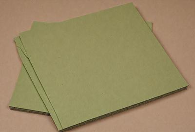 The primary subject of the image is a pair of green books. The books are placed on a pink surface, which serves as the setting or background. The visual style of the image is a photo, capturing the details of the books and the surface they are placed on. The colors and mood of the image are predominantly green, with the books and the surface both having a green hue.