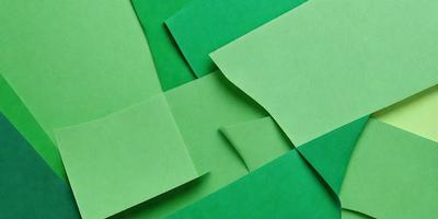 The primary subject of the image is a stack of green paper, which is the main object, scene, or focus of the image. The setting is a green background, which adds to the overall atmosphere. The visual style is a photo, and the colors and mood are predominantly green, creating a calm and serene environment.