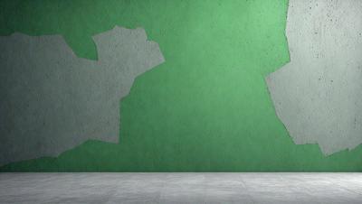 The primary subject of the image is a green wall with a large hole in it. The setting is a room with a concrete floor. The visual style is a photo, and the colors and mood are predominantly green, with a slightly damaged or worn appearance.