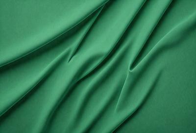The primary subject of the image is a green fabric, which is the main object, scene, or focus of the image. The setting or background is a green cloth, and the visual style is a photo. The colors and mood of the image are predominantly green, creating a calm and soothing atmosphere.