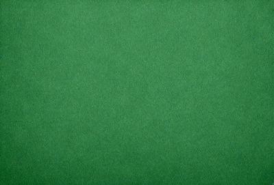 The primary subject of the image is a large, green, textured surface. The setting is a brightly lit room, and the visual style is a close-up of the green surface. The colors and mood of the image are predominantly green, creating a calm and serene atmosphere.