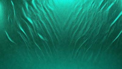 The primary subject of the image is a close-up of a green ocean surface, featuring a pattern of waves and ripples. The setting is underwater, with the background being the ocean floor. The visual style is a photo of the ocean, capturing the natural beauty of the underwater environment. The dominant colors are green and blue, creating a serene and calming atmosphere.