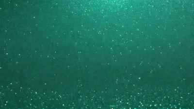 The primary subject of the image is a close-up of a green background with a pattern of glittering stars. The setting appears to be a dark room, and the visual style is a combination of a photo and digital art. The dominant colors are green and black, creating a moody and atmospheric scene.