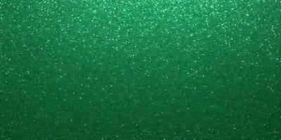 The primary subject of the image is a green background with a pattern of glittering green dots. The setting is a close-up of the green background, which creates a visually striking and unique visual style. The colors and mood of the image are predominantly green, with the glittering dots adding a touch of sparkle and interest to the overall atmosphere.