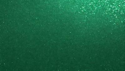 The primary subject of the image is a green background with a glittery texture. The setting is a dark room, and the visual style appears to be a digital art or illustration. The dominant colors are green and black, creating a moody and mysterious atmosphere.