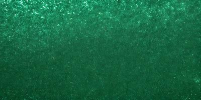 The primary subject of the image is a green background with a pattern of glittering stars. The setting is a dark room, and the visual style appears to be a digital art or illustration. The dominant colors are green and white, creating a calm and serene atmosphere.