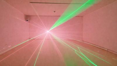 The primary subject of the image is a brightly lit room with a pink wall. The setting is a white room, and the visual style appears to be a combination of a photo and digital art. The dominant colors in the image are pink and green, creating a vibrant and lively atmosphere.