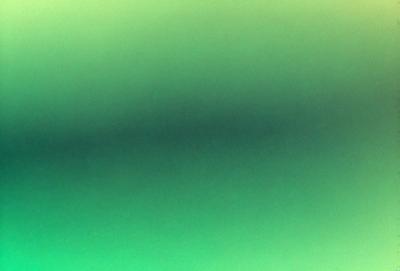 The primary subject of the image is a green background. The setting is a dark, greenish-blue background, which creates a moody atmosphere. The visual style is a close-up of the green background, showcasing the vibrant color.