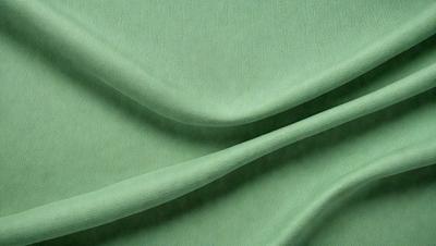 The primary subject of the image is a green fabric, which is the main object, scene, or focus of the image. The setting or background is a green cloth, and the visual style is a photo. The colors and mood of the image are predominantly green, creating a calm and soothing atmosphere.
