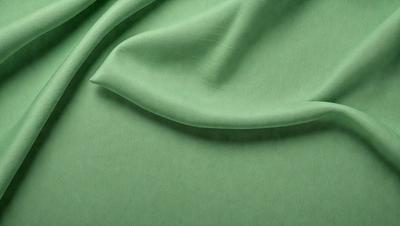The primary subject of the image is a green fabric, which is the main object, scene, or focus of the image. The setting or background is a green cloth, and the visual style is a photo. The colors and mood of the image are predominantly green, creating a calm and soothing atmosphere.