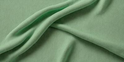 The primary subject of the image is a green fabric, which is the main object, scene, or focus of the image. The setting or background is a green surface, which complements the green fabric. The visual style of the image is a close-up of the green fabric, showcasing its texture and details. The colors and mood of the image are predominantly green, creating a calm and soothing atmosphere.