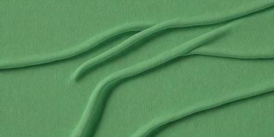 The primary subject of the image is a green surface with a pattern of long, curved lines. The setting appears to be a textured surface, possibly a wall or a piece of fabric. The visual style of the image is a close-up of the green surface, showcasing the intricate pattern of the lines. The colors and mood of the image are predominantly green, creating a calm and soothing atmosphere.