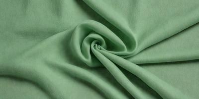 The primary subject of the image is a green fabric, which is the main object, scene, or focus of the image. The setting or background is a green cloth, and the visual style is a photo. The colors and mood of the image are predominantly green, creating a calm and soothing atmosphere.