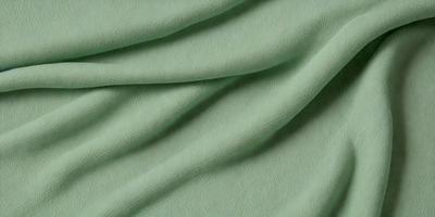 The primary subject of the image is a green fabric, which appears to be a piece of cloth or a blanket. The setting is a close-up view of the fabric, showcasing its texture and color. The visual style is a realistic representation of the fabric, and the colors and mood are predominantly green, giving the image a calm and soothing atmosphere.
