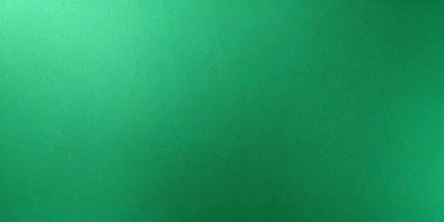 The primary subject of the image is a green background. The setting is a large, unoccupied space with a green surface. The visual style is a close-up of the green background, which gives a sense of depth and texture. The colors and mood of the image are predominantly green, creating a calm and serene atmosphere.