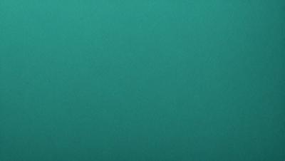 The primary subject of the image is a large, green, textured surface. The setting is a dark room, and the visual style appears to be a photo. The dominant colors are green and black, creating a moody atmosphere.