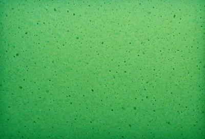 The primary subject of the image is a green wall with a pattern of white dots. The setting is a room with a green background. The visual style is a close-up of the green wall, showcasing the dots pattern. The colors and mood of the image are predominantly green and white, creating a calm and soothing atmosphere.
