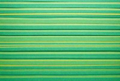 The primary subject of the image is a green striped paper. The setting is a green background, and the visual style is a pattern. The colors and mood are predominantly green, creating a calm and soothing atmosphere.