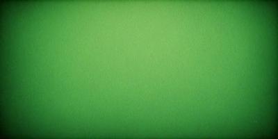 The primary subject of the image is a large, bright green wall. The setting is a plain, empty room with no other objects or people visible. The visual style is a close-up of the green wall, which gives a sense of depth and texture. The colors and mood of the image are predominantly green, creating a calm and serene atmosphere.