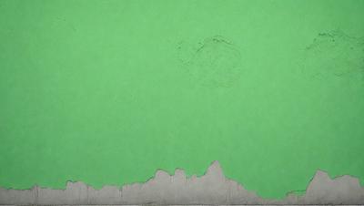 The primary subject of the image is a green wall with a hole in it. The setting is an indoor environment, possibly a room or a building. The visual style is a photo, capturing the hole in the green wall. The colors and mood of the image are predominantly green, with a slightly darker tone due to the hole in the wall.