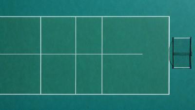 The image features a tennis court with a blue background. The court is marked with white lines, indicating the boundaries of the playing area. The court is surrounded by a blue surface, which adds to the overall aesthetic of the scene. The image is a digital art or illustration, showcasing the tennis court in a visually appealing manner.