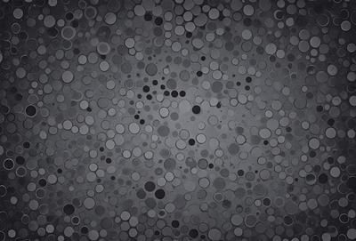 The primary subject of the image is a pattern of circles, which are scattered across a black background. The circles vary in size and are arranged in a visually appealing manner. The setting appears to be a dark or black background, which contrasts with the circles, making them stand out. The visual style of the image is a combination of a pattern and a texture, creating a unique and intriguing appearance. The overall atmosphere of the image is somewhat mysterious and captivating, as the viewer is drawn to the circles and their
