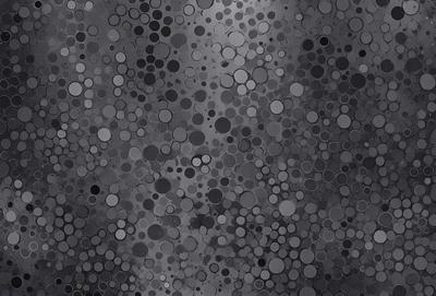 The primary subject of the image is a pattern of circles, which are scattered across a gray background. The setting appears to be a dark room, and the visual style is a close-up of the circles. The dominant colors are gray and black, creating a moody atmosphere.