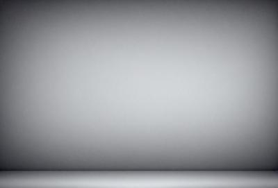The primary subject of the image is a large, empty white wall. The setting is a room with a gray background, which creates a stark contrast with the white wall. The visual style is a simple, clean, and minimalist design. The colors and mood of the image are predominantly white and gray, giving it a calm and uncluttered atmosphere.