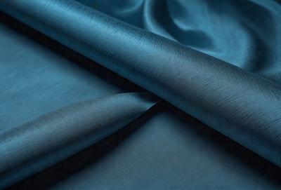The primary subject of the image is a blue fabric, possibly a piece of cloth or a piece of leather. The setting is a dark room, and the visual style appears to be a close-up of the fabric. The colors and mood of the image are predominantly dark and moody, with the blue fabric being the main focus.