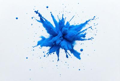 The primary subject of the image is a blue splash of paint, which appears to be a blue blob or a blue explosion. The setting is a white background, which provides a clean and uncluttered environment for the blue splash. The visual style of the image is a combination of a photo and digital art, as it captures the vibrant blue color and the dynamic nature of the splash. The colors and mood of the image are predominantly blue, creating a sense of energy and movement.