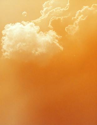 The primary subject of the image is a cloudy sky with a few clouds scattered throughout. The setting is an outdoor environment, possibly during sunset, as the sky appears to be orange. The visual style of the image is a photo, capturing the natural beauty of the cloudy sky. The colors and mood of the image are warm and serene, with the orange hues of the sky creating a peaceful atmosphere.