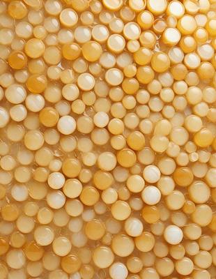 The primary subject of the image is a close-up of a yellow substance, which appears to be a mixture of beads and a yellowish substance. The setting is a surface with a pattern of yellow beads, creating a visually interesting and unique pattern. The visual style of the image is a close-up, which emphasizes the details of the yellow substance. The colors and mood of the image are predominantly yellow, giving it a warm and inviting atmosphere.