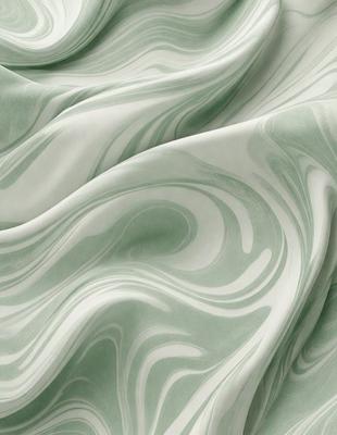The primary subject of the image is a green fabric with a pattern of swirls and waves. The setting is a close-up view of the fabric, showcasing its intricate design. The visual style is a detailed, textured image that highlights the fabric's unique pattern. The colors and mood of the image are predominantly green, creating a calm and soothing atmosphere.