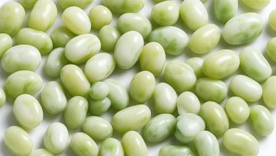 The primary subject of the image is a large group of green beans, which are the main objects in the scene. The beans are arranged on a white surface, creating a clean and simple visual style. The colors in the image are predominantly green, which gives the scene a fresh and natural atmosphere.