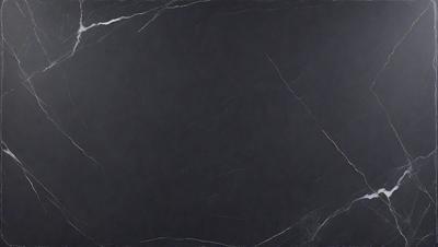 The primary subject of the image is a black marble countertop. The setting is a dark room, and the visual style is a close-up of the marble countertop. The colors and mood of the image are dark and moody, with the black marble countertop being the main focus.