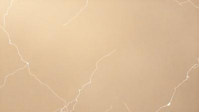 The primary subject of the image is a close-up of a wall with a light brown color. The setting is indoors, possibly in a room with a tan-colored wall. The visual style appears to be a photo, as it captures the details of the wall and its texture. The colors and mood of the image are warm and inviting, with the light brown color creating a sense of comfort and relaxation.