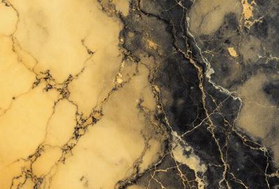The primary subject of the image is a marble wall with a gold and black color scheme. The setting is a room with a marble surface, and the visual style is a close-up of the marble wall. The colors and mood of the image are elegant and sophisticated, with the gold and black tones creating a luxurious and timeless atmosphere.