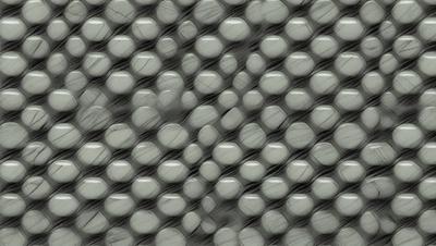 The primary subject of the image is a pattern of small, round, shiny objects, possibly marbles or glass beads, arranged in a visually appealing manner. The setting is a gray background, which contrasts with the bright colors of the objects. The visual style is a close-up of the pattern, showcasing the intricate details of the arrangement. The colors and mood of the image are vibrant and lively, with the small objects creating a sense of depth and texture.