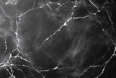 The primary subject of the image is a marble countertop with a black background. The countertop appears to be a marble slab, and the overall atmosphere is elegant and sophisticated. The visual style of the image is a close-up of the marble countertop, showcasing its texture and details.