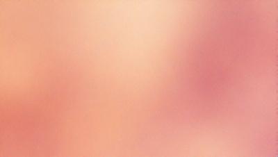 The primary subject of the image is a close-up of a person's face, with a focus on the skin. The setting is a pink background, which adds a warm and soft atmosphere to the scene. The visual style appears to be a photo, capturing the details of the person's face. The colors and mood convey a sense of intimacy and personal connection.