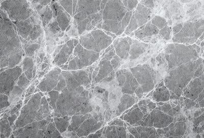 The image features a gray marble wall with a pattern of white and gray veins. The wall appears to be textured and has a unique, natural appearance. The primary subject of the image is the marble wall, which serves as the main focus of the scene. The setting is indoors, likely in a building or a room with a similar design. The visual style of the image is a close-up of the marble wall, showcasing its intricate patterns and textures. The colors and mood of the image