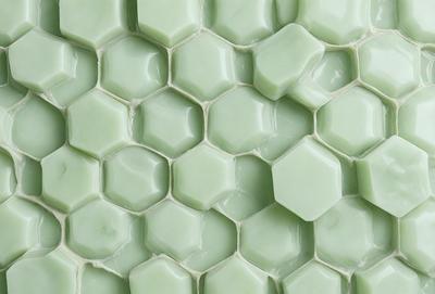The primary subject of the image is a close-up of a green tile wall. The setting is a room with a green tile wall, which is the main object of the image. The visual style is a close-up of the green tile wall, and the colors and mood are predominantly green, giving the image a calm and soothing atmosphere.