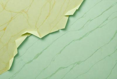 The primary subject of the image is a green marble wall with a yellowish tint. The setting is a room with a green background. The visual style is a photo of the marble wall. The dominant colors are green and yellow, creating a warm and natural atmosphere.