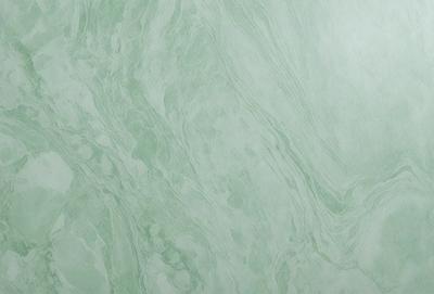 The image features a green marble wall with a patterned texture. The wall appears to be made of marble, giving it a luxurious and elegant appearance. The green color of the marble adds a sense of freshness and natural beauty to the scene.